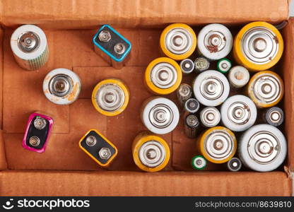 Discharged batteries in cardboard box. Collecting used batteries to recycle. Waste disposal and recycling. Copy space for text