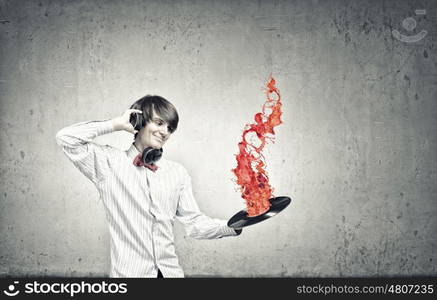 Disco dj. Young man dj wearing headphones and holding plate