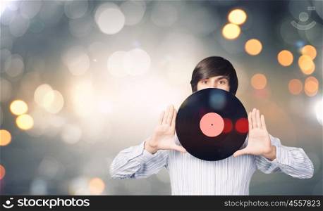 Disco party. Young handsome man with disco plate in hands