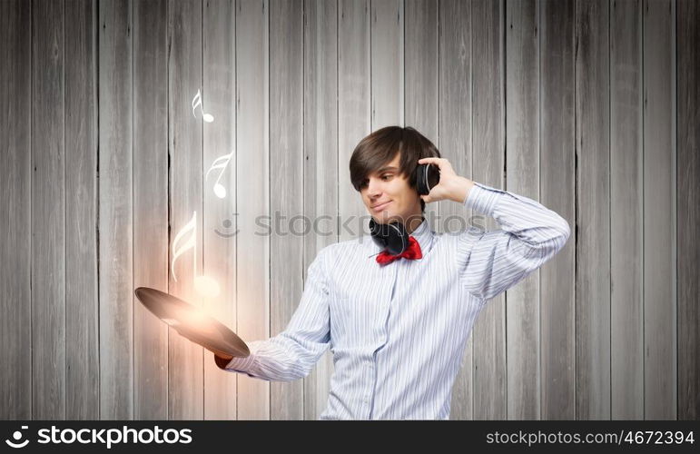 Disco party. Young handsome man with disco plate in hands