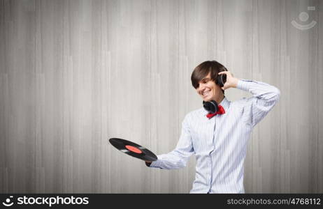 Disco party. Young handsome man with disco plate in hands