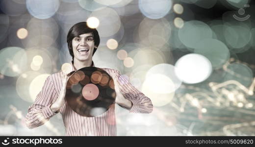 Disco party. Young handsome man with disco plate in hands