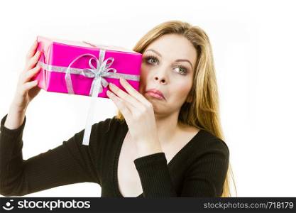 Discontent girl holding pink gift box
