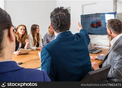 Discussion during a business meeting in a conference room - mixed caucasian team rather casual, ambiente might suggest a startup or an agency