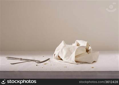 Dish cloth, cutlery and crumbs on table