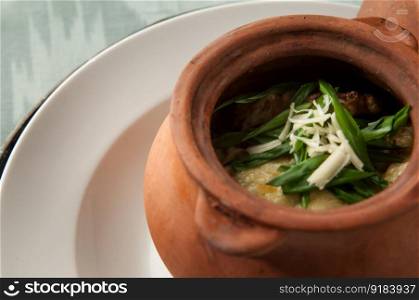 dish in a clay pot closeup. soups on a tray