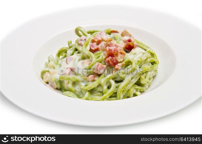 dish of green spaghetti with bacon and cream