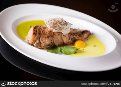 dish of meat with egg in a plate, on a black background, isolated. dish on black background