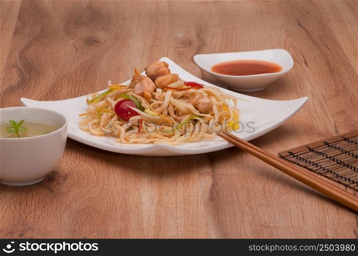 dish of noodles with meat on a plate with chopsticks. noodles in a plate
