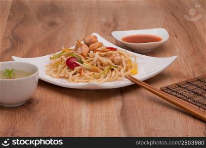 dish of noodles with meat on a plate with chopsticks. noodles in a plate
