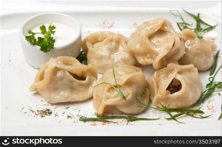 dish of ravioli with sour cream isolated on white background