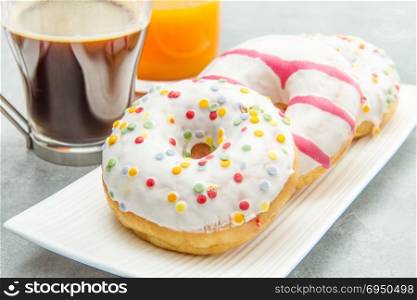 dish with assorted donuts, coffee and juice