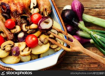 Dish with baked chicken potato with fresh vegetables.Photo tinted. Chicken with potatoes and vegetables