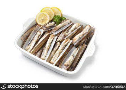 Dish with fresh cooked razor shells on white background
