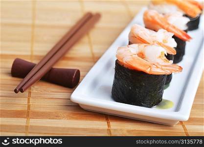 dish with fresh sushi rolls on bamboo napkin background