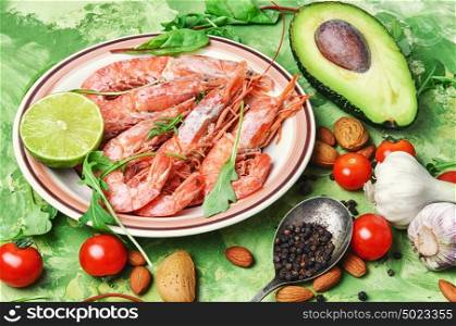 Dish with large prawns and seasonal vegetables. Delicious shrimp with lime sauce,greens,avocado and tomatoes