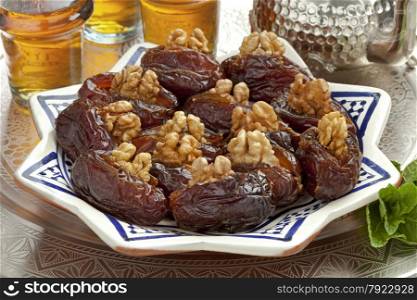 Dish with preserved ripe Medjool dates stuffed with walnuts for festive occasions