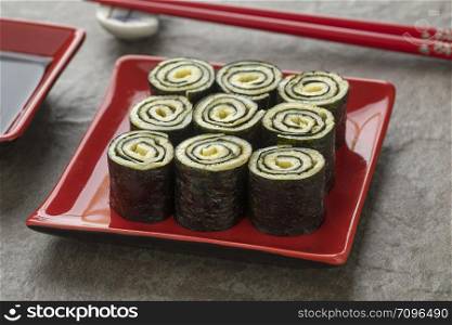 Dish with traditional Japanese egg rolls with nori close up
