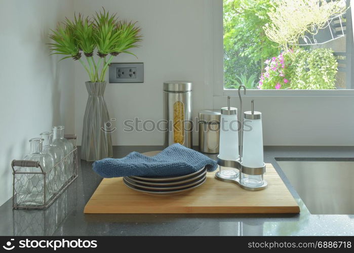 Dishes and glass bottles setting on black counter top in the kitchen