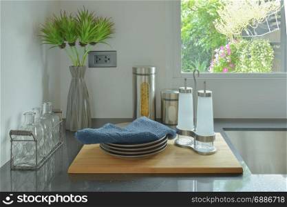 Dishes and glass bottles setting on black counter top in the kitchen