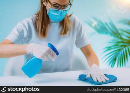 Disinfect - Woman Spraying Table Surface with Disinfectant and Wiping it with a Cloth. Surface Disinfection. Woman Disinfecting Table Surface