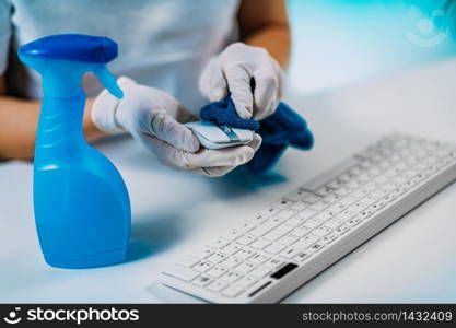 Disinfection of Computer Keyboard and Mouse. Woman disinfecting Computer Keyboard and Mouse with Alcohol-based disinfectant
