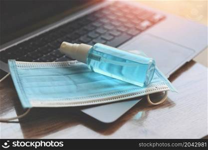 Disinfects the surface of the laptop by sanitizer spray or alcohol gel washing hand hygiene and face mask on the working place for quarantine coronavirus covid-19 working from home concept.
