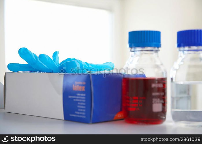 Disposable Latex Gloves and Bottles in Lab