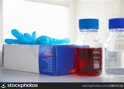 Disposable Latex Gloves and Bottles in Lab
