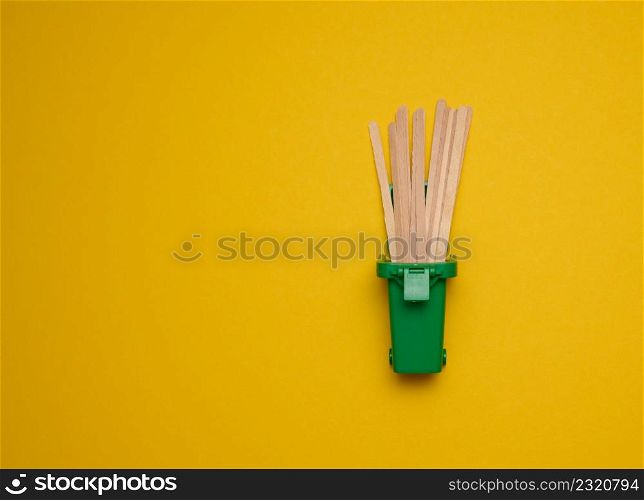 disposable wooden sticks for stirring hot drinks on a yellow background. Coffee and tea spoon, zero waste