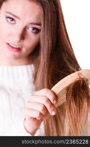 Dissatisfied woman combing with brush and pulls at her long hair. Being unhappy for nice look in daily activity.. Woman combing and pulls hair.
