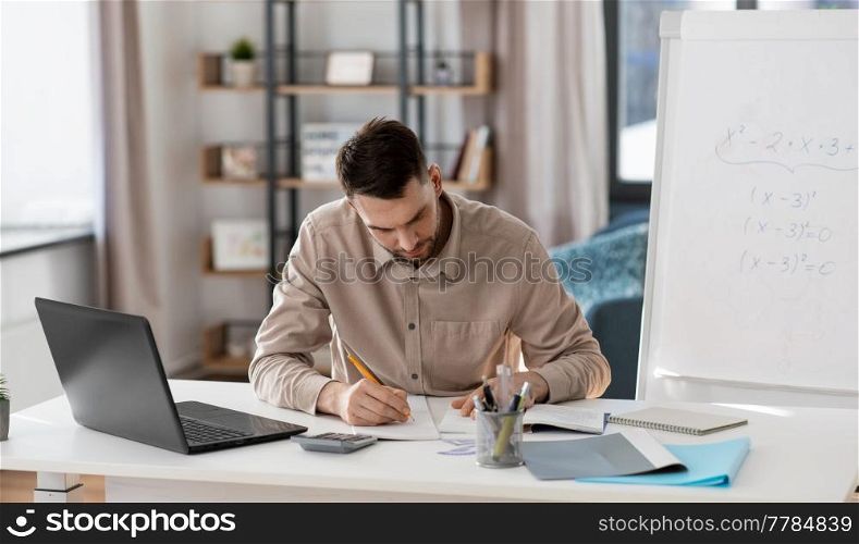 distance education, remote job and stress concept - male teacher with laptop computer working at home office. male teacher with laptop working at home