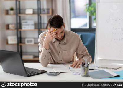 distance education, remote job and stress concept - tired male teacher with laptop computer working at home office. tired male teacher with laptop working at home