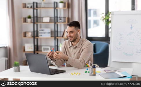 distance education, school and remote job concept - happy smiling male chemistry teacher with laptop computer and molecular model having online class at home office. chemistry teacher with laptop having online class