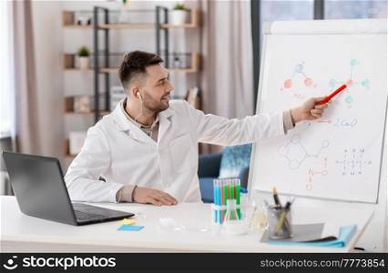 distance education, school and science concept - happy smiling male chemistry teacher in earphones with laptop computer having online class and showing molecular model on flip chart at home office. chemistry teacher with laptop having online class