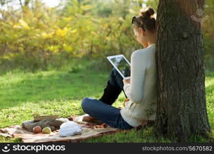 Distance education. Sitting woman using ipad during stroll outdoors