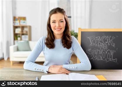 distant education, primary school and teaching concept - female teacher having online class or video call at home. teacher having online class or video call at home