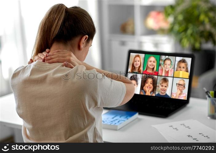 distant education, remote job and health concept - tired female teacher having online class with group of students on laptop computer and touching her aching neck at home office. tired teacher with laptop touching neck at home