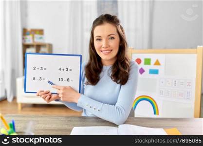 distant education, school and people concept - happy smiling female math teacher with mathematics having online class at home. math teacher having online class at home
