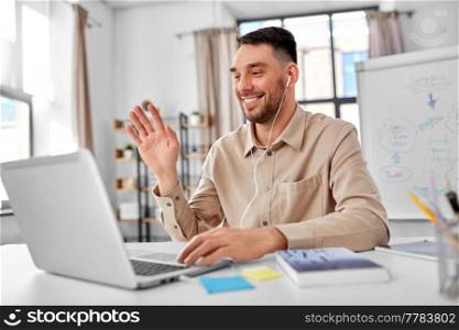 distant education, school and remote job concept - happy smiling male teacher with laptop computer having online class or video call at home office. teacher with laptop having online class at home