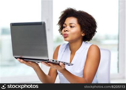distant relationship, online communication and love concept - happy young african american woman sending kiss to laptop computer