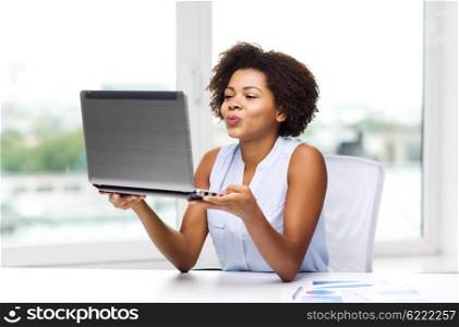 distant relationship, online communication and love concept - happy young african american woman sending kiss to laptop computer