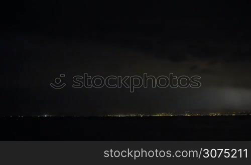 Distant view of lightnings flashing in dark night sky over the city. Thunderstorm is coming