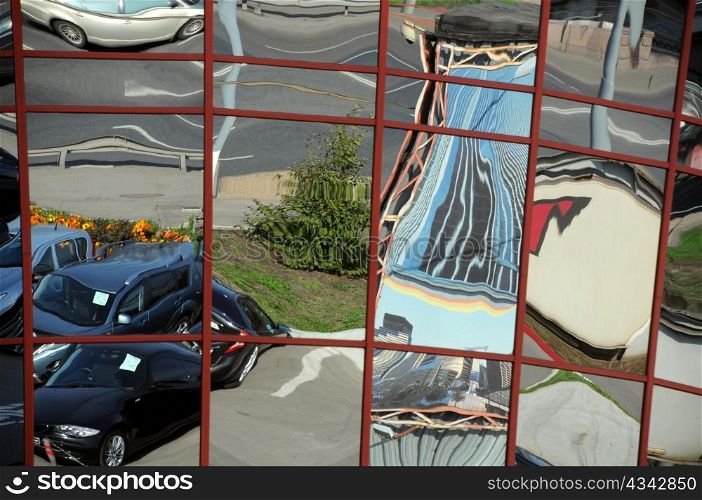 Distorted reflection of cars and houses in the modern city