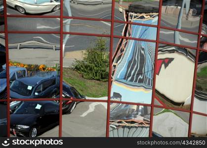 Distorted reflection of cars and houses in the modern city