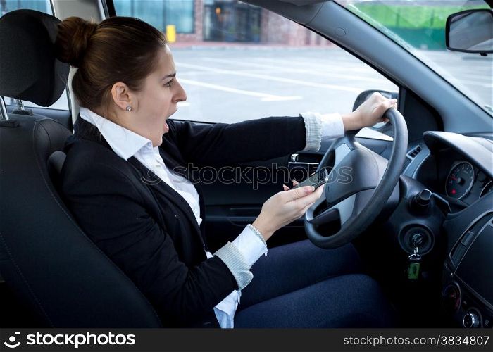 Distracted woman using smartphone while driving a car