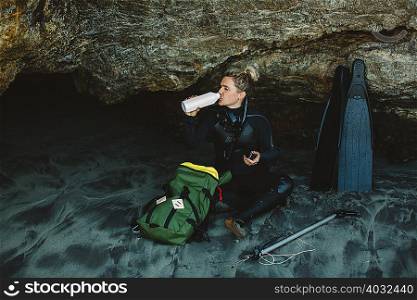 Diver with speargun resting on beach, Big Sur, California, USA