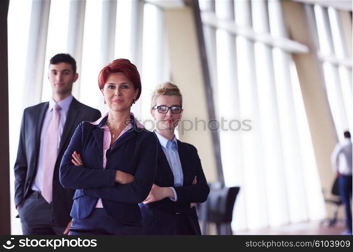 diverse business people group standing together as team in modern bright office interior with redhair senior woman in front as leader
