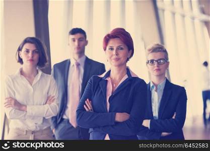 diverse business people group standing together as team in modern bright office interior with redhair senior woman in front as leader