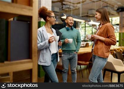 Diverse business team laughing cheerfully in coworking office. Successful young businesspeople taking short break during work. Diverse business team laughing cheerfully in coworking office
